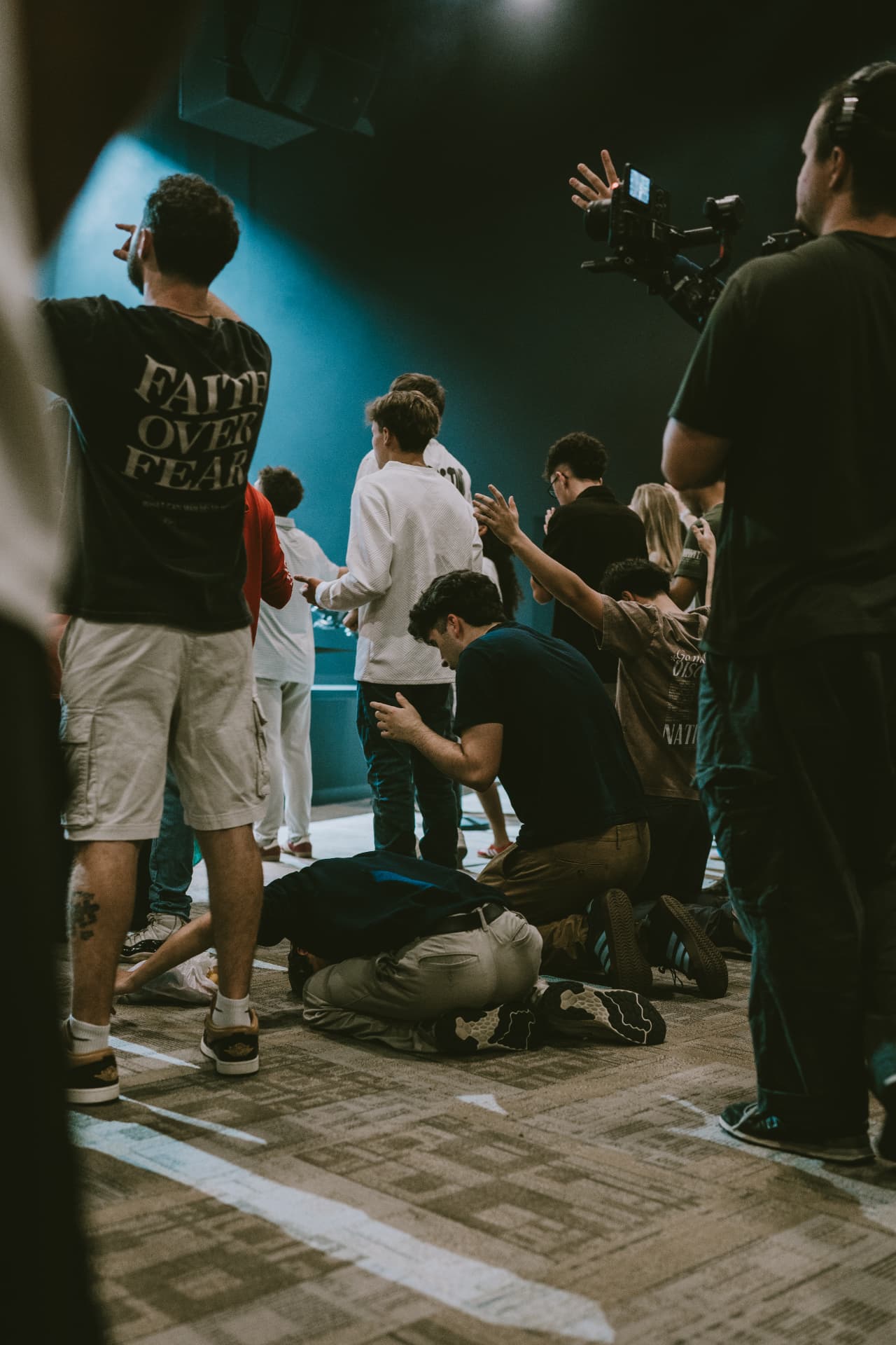 Congregation kneeling and reaching toward Jesus during worship